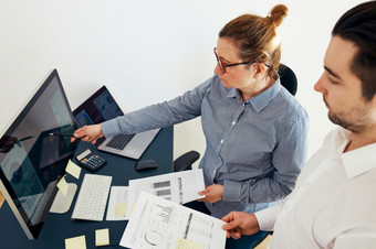 女商人讨论金融数据与她的的<strong>同事</strong>站桌子上办公室女人企业家工作与图表和表电脑两个人工作在<strong>一起同事</strong>会说话的关于项目