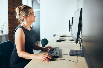 有关女商人工作电脑办公室忙女人坐着桌子上前面电脑监控聚焦工作开放办公室复制空间正确的