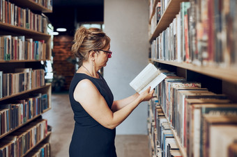女人阅读书公共图书馆老师搜索为文学为阅读和学习女人站在书架好处日常阅读书货架上书店