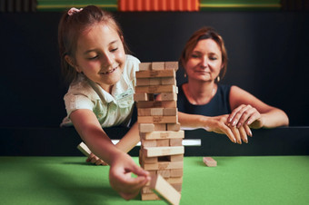 妈妈。和她的女儿玩在app store中查看游戏在一起玩房间女孩删除一个块从堆栈和放置前塔堆放木块游戏技能和有趣的家庭时间
