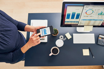 女商人工作与金融数据图表和表智能手机和电脑女人企业家看出售统计数据站桌子上办公室