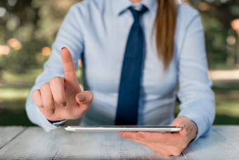 业务概念与女业务人坐着的表格和持有移动电话业务女人概念与移动电话业务概念与女业务人坐着的表格和持有移动电话