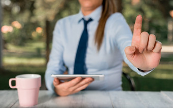 业务概念与女业务人坐着的表格和持有移动电话业务女人概念与移动电话和杯咖啡业务概念与女业务人坐着的表格和持有移动电话