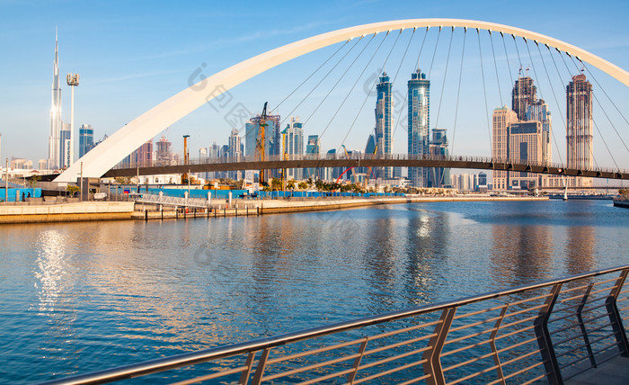 色彩斑斓的日落在迪拜市中心摩天大楼和的新建宽容桥查看从的迪拜水运河