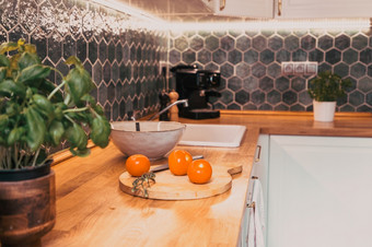 新鲜的西红柿和罗勒现代厨房室内与白色家具首页背景