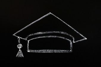 挖沟机帽为毕业概念画与粉笔黑板上背景