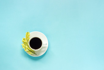 杯咖啡和黄色的野生花linaria蓝色的纸背景平躺前视图概念好早....你好春天复制空间模板为明信片文本你的设计杯咖啡和黄色的野生花linaria蓝色的纸背景平躺前视图概念好早....你好春天复制空间