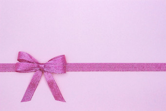 装饰闪亮的丝带与弓关闭柔和的粉红色的背景与复制空间为文本前视图布局装饰闪亮的丝带与弓粉红色的背景