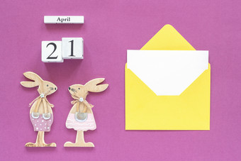 日历4月一对木复活节小兔子黄色的信封与空白卡紫色的纸背景概念天主教复活节模型模板为刻字文本你的设计前视图日历4月一对木复活节小兔子黄色的信封与空白卡紫色的纸背景概念天主教复活节模型模板为刻字文本你的设