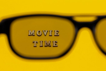 焦点文本电影时间通过眼镜黄色的纸背景概念电影电影和娱乐焦点文本电影时间通过眼镜黄色的纸背景概念电影电影和娱乐