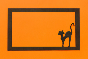 万圣节背景黑色的纸猫黑色的框架橙色背景快乐万圣节概念空间为文本前视图模型布局平躺万圣节背景黑色的纸猫黑色的框架橙色背景