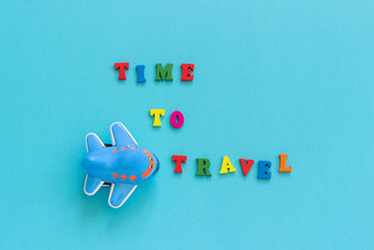 色彩斑斓的文本时间旅行和孩子们rsquo有趣的玩具飞机蓝色的纸背景复制空间前视图概念旅游模板为明信片问候卡色彩斑斓的文本时间旅行和孩子们rsquo有趣的玩具飞机蓝色的纸背景复制空间前视图概念旅游模板为