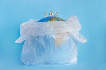 地球地球塑料袋和登记Sos蓝色的背景概念生态地球污染与塑料玻璃纸聚乙烯地球一天世界环境一天