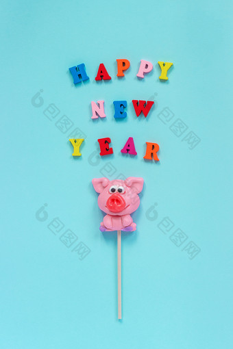 有趣的粉红色的猪棒棒糖和多色登记快乐新一年蓝色的背景前视图布局概念问候卡一年的猪猪棒棒糖和文本快乐新一年