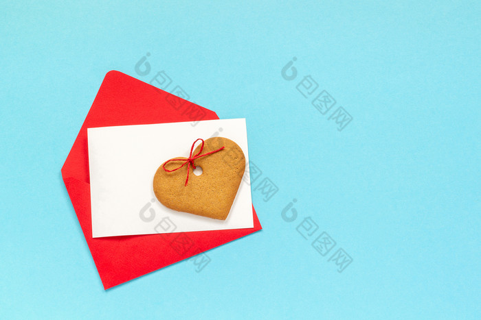 红色的信封与空白白色卡为文本和心形状的姜饼干蓝色的背景前视图复制空间模拟概念信问候与爱红色的信封与空白白色卡为文本和心形状的姜饼干蓝色的背景