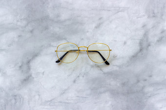 时尚的黄金眼镜演出大理石背景前视图复制空间最小的风格时尚的黄金眼镜演出大理石背景前视图复制空间最小的风格