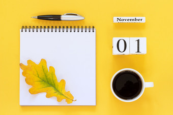 秋天作文木日历11月杯咖啡空开放记事本与笔和黄色的橡木叶黄色的背景前视图平躺模型概念你好11月日历11月杯咖啡记事本与笔和黄色的叶黄色的背景