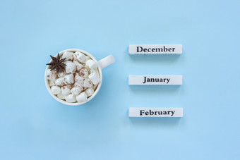 木日历冬天个月12月1月2月和杯可可与棉花糖茴香明星目的是12月蓝色的背景概念前视图平躺问候卡杯可可棉花糖和日历12月1月2月蓝色的背景