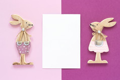 浪漫的作文一对木情人小雕像兔子和白色空白卡为文本粉红色的紫色的背景概念情人节rsquo卡前视图平躺模型浪漫的作文一对木情人小雕像兔子和白色空白卡为文本粉红色的紫色的背景概念情人节rsquo卡前视图平躺