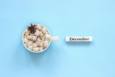 木日历冬天月12月和杯可可与棉花糖茴香明星蓝色的背景概念前视图平躺问候卡杯可可棉花糖和日历12月蓝色的背景