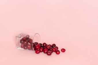 下降玻璃与分散红色的成熟的甜蜜的樱桃粉红色的背景概念新鲜的自然汁冰沙健康的吃饮食模板为文本你的设计复制空间下降玻璃与分散红色的成熟的甜蜜的樱桃粉红色的背景概念新鲜的自然汁冰沙健康的吃饮食模板为文本你的