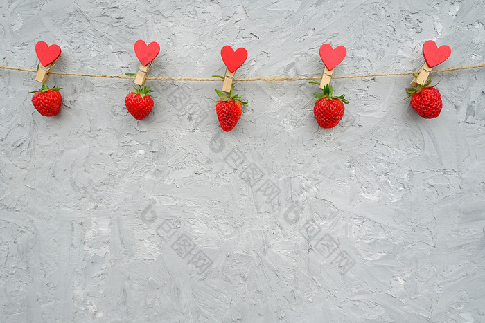 加兰红色的成熟的草莓挂木衣夹与心绳子线位于前边缘灰色的背景复制空间有创意的模板为文本设计明信片邀请加兰红色的成熟的草莓挂木衣夹与心绳子线位于前边缘灰色的背景复制空间有创意的模板为文本设计明信片邀请