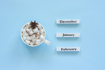 木日历冬天个月12月1月2月和杯可可与棉花糖茴香明星目的是2月蓝色的背景概念前视图平躺问候卡杯可可棉花糖和日历12月1月2月蓝色的背景