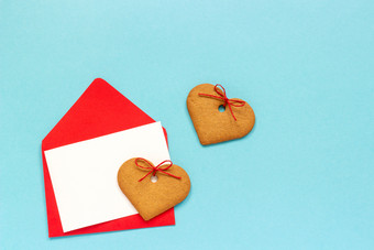 红色的信封与<strong>空白</strong>白色卡为文本和心形状的姜饼干蓝色的背景前视图复制空间模拟概念信问候与爱红色的信封与<strong>空白</strong>白色卡为文本和心形状的姜饼干蓝色的背景