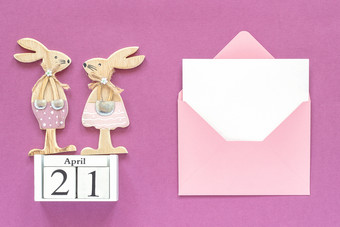 日历4月一对木复活节小兔子粉红色的信封与空白卡紫色的纸背景概念天主教复活节模型模板为刻字文本你的设计前视图日历4月一对木复活节小兔子粉红色的信封与空白卡紫色的纸背景概念天主教复活节模型模板为刻字文本你