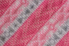 针织织物与模式系与粉红色的灰色和白色纱手工制作的背景纹理