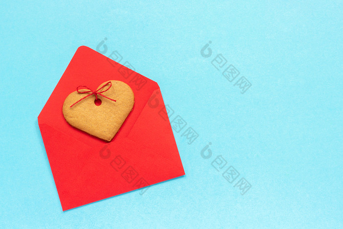 红色的信封和心形状的姜饼干蓝色的背景前视图复制空间概念信问候与爱红色的信封和心形状的姜饼干蓝色的背景