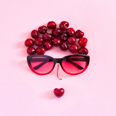 摘要glamur年轻的女人甜蜜的樱桃和眼镜粉红色的背景概念青年美夏天仍然生活前视图平躺