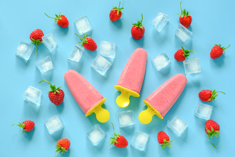 自制的冰棍自然冰奶油明亮的塑料模具草莓和冰多维数据集蓝色的背景前视图平躺自制的冰棍自然冰奶油明亮的塑料模具草莓和冰多维数据集蓝色的背景前视图平躺