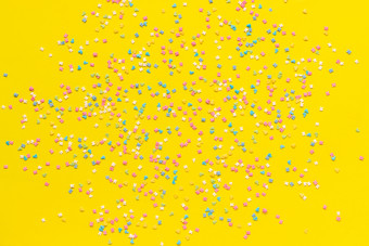 散射五彩缤纷的糖果一流的沙拉酱黄色的纸节日背景复制空间前视图散射五彩缤纷的糖果一流的沙拉酱黄色的纸节日背景复制空间前视图