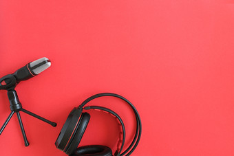 耳机和麦克风红色的背景概念音乐播客前视图平躺复制空间耳机和麦克风红色的背景概念音乐播客前视图平躺复制空间