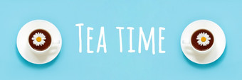 茶时间文本和两个白色杯茶与洋甘菊菜飞碟蓝色的背景前视图平躺横幅茶时间文本和两个白色杯茶与洋甘菊菜飞碟蓝色的背景前视图平躺横幅