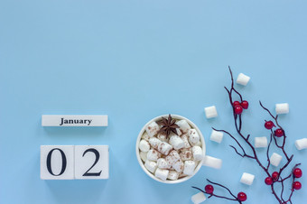 冬天作文白色木日历多维数据集数据1月杯可可与棉花糖和装饰分支与红色的浆果蓝色的背景前视图平躺复制空间日历1月杯可可棉花糖和分支浆果
