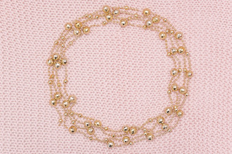 圆框架从金珠子加兰针织粉红色的背景前视图平躺模板为设计圆框架从金珠子加兰针织粉红色的背景前视图平躺模板为设计