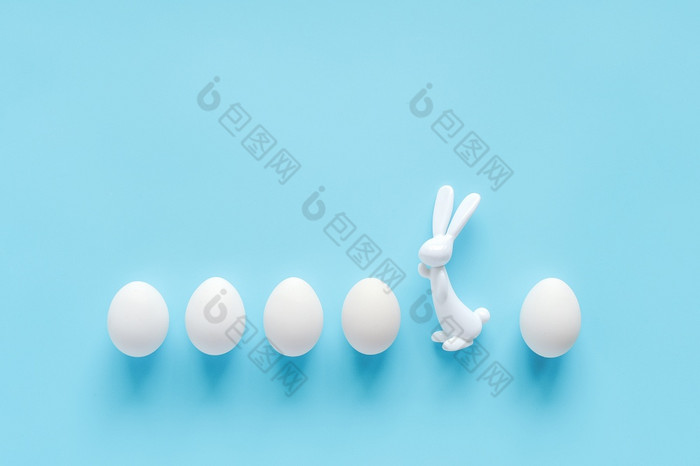 行白色鸡蛋和兔子兔子小雕像蓝色的背景与复制空间快乐复活节不就像每一个人其他的概念有创意的平躺前视图模板为问候卡邀请明信片行白色鸡蛋和兔子兔子小雕像蓝色的背景与复制空间快乐复活节不就像每一个人其他的概念