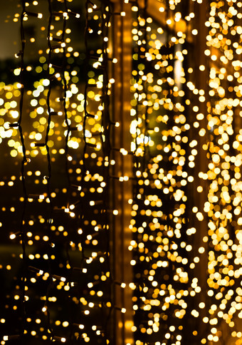 圣诞节装饰使发光的加兰新一年照明明亮的黄色的和金闪闪发光的灯背景散焦闪闪发光的光圣诞节装饰使发光的加兰新一年照明明亮的黄色的和金闪闪发光的灯背景散焦