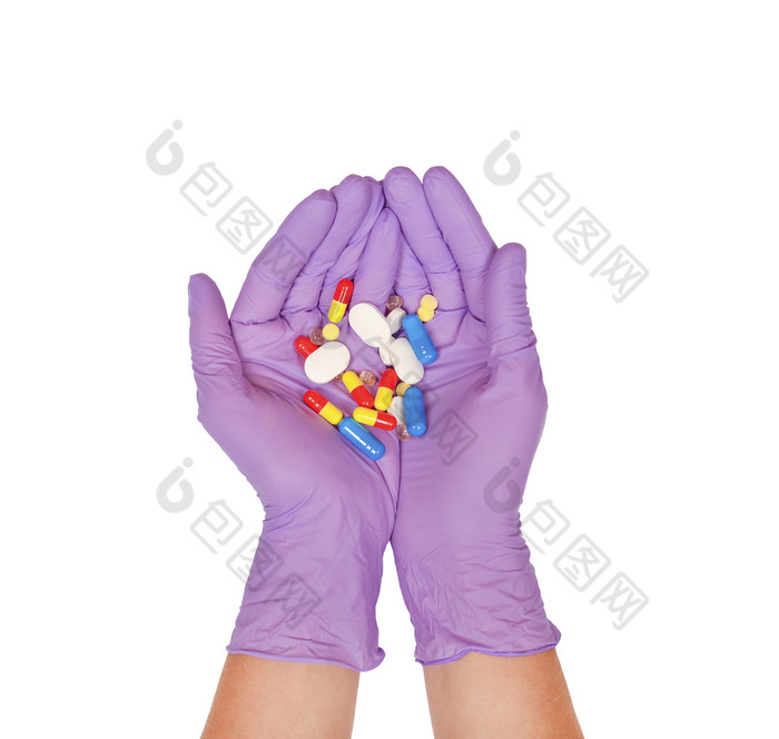 手掌紫色的乳胶手套持有一些药片手与药片孤立的白色医学治疗概念手掌紫色的乳胶手套持有一些药片