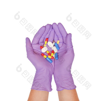 手掌紫色的乳胶手套持有一些药片手与药片孤立的白色医学治疗概念手掌紫色的乳胶手套持有一些药片