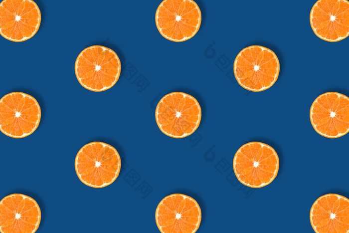 水果模式新鲜的明亮的橙色柑橘类片孤立的经典蓝色的背景平躺前视图流行艺术设计有创意的颜色的一年概念最小的风格水果模式新鲜的明亮的橙色柑橘类片孤立的经典蓝色的背景