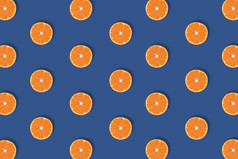 水果模式新鲜的明亮的橙色柑橘类片孤立的经典蓝色的背景平躺前视图流行艺术设计有创意的颜色的一年夏天概念最小的风格水果模式新鲜的明亮的橙色柑橘类片孤立的经典蓝色的背景平躺前视图