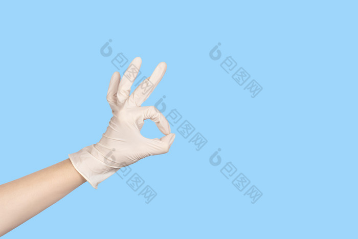 手手势手白色乳胶手套显示标志孤立的蓝色的背景复制空间手白色乳胶手套显示标志孤立的蓝色的背景