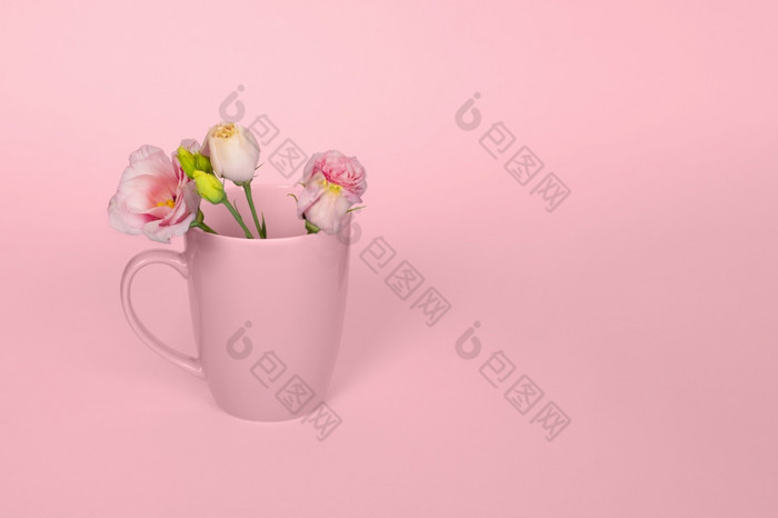 有创意的单色概念使咖啡茶杯与温柔的粉红色的eustoma花光粉红色的背景复制空间粉红色的eustoma花的粉红色的杯粉红色的eustoma花的粉红色的杯