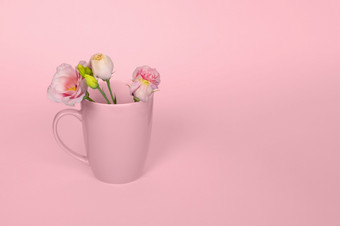 有创意的单色概念使咖啡茶杯与温柔的粉红色的eustoma花光粉红色的背景复制空间粉红色的eustoma花的粉红色的杯粉红色的eustoma花的粉红色的杯