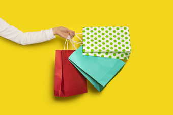购物出售概念女手持有购物<strong>纸袋</strong>孤立的黄色的背景横幅女手持有购物<strong>纸袋</strong>孤立的黄色的背景