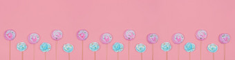 色彩斑斓的棉花糖蛋白酥皮蛋糕装饰柔和的粉红色的背景长时尚的横幅与棉花糖坚持和复制空间时尚的横幅与marshmallowor蛋白酥皮坚持