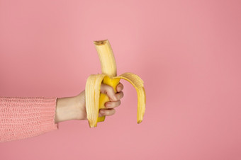 女手持有明亮的黄色的咬香蕉时尚的单色横幅与复制空间女手持有明亮的黄色的咬香蕉